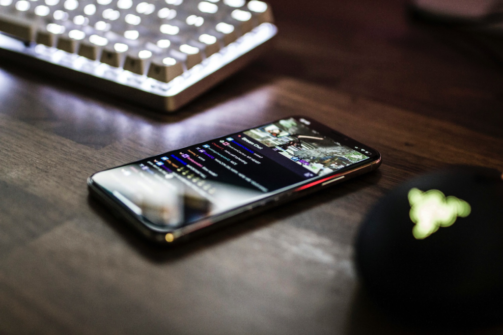 A close-up of a smartphone placed next to a computer keyboard.