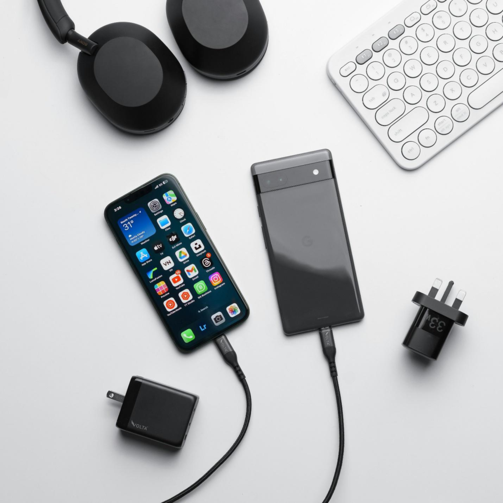 two smartphones connected to a charging cable