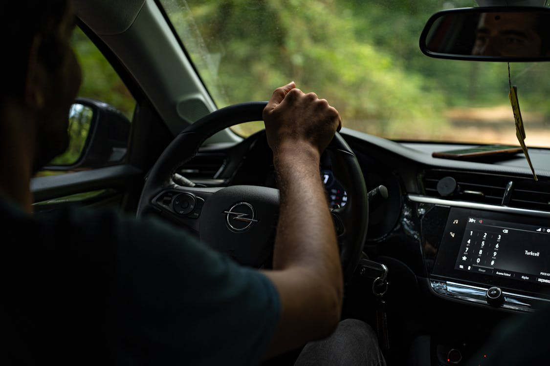 A man driving a car focused on the road ahead.