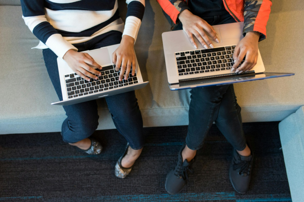 Two people working on laptops